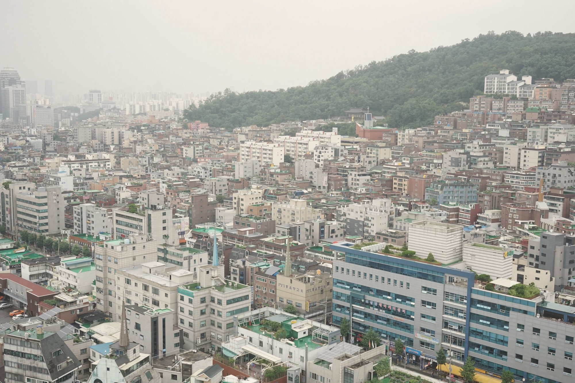 산자락 아래 다세대·다가구 밀집 주거지 전경 — 위반건축물 양성화 상담 예시